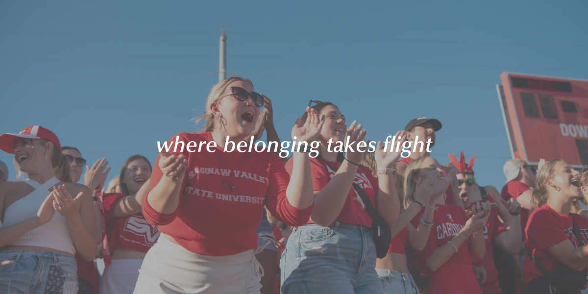 Students cheering in the student section of an SVSU football game with text overlaying the image that says 